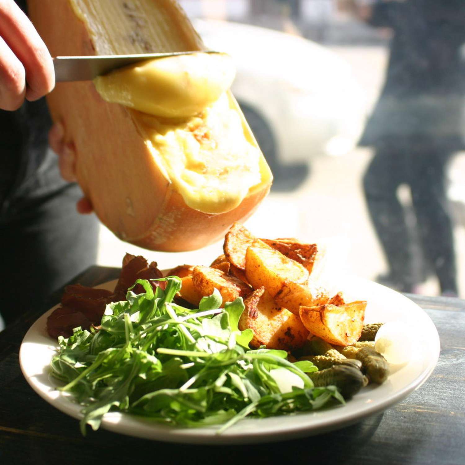 Raclette shaved onto greens