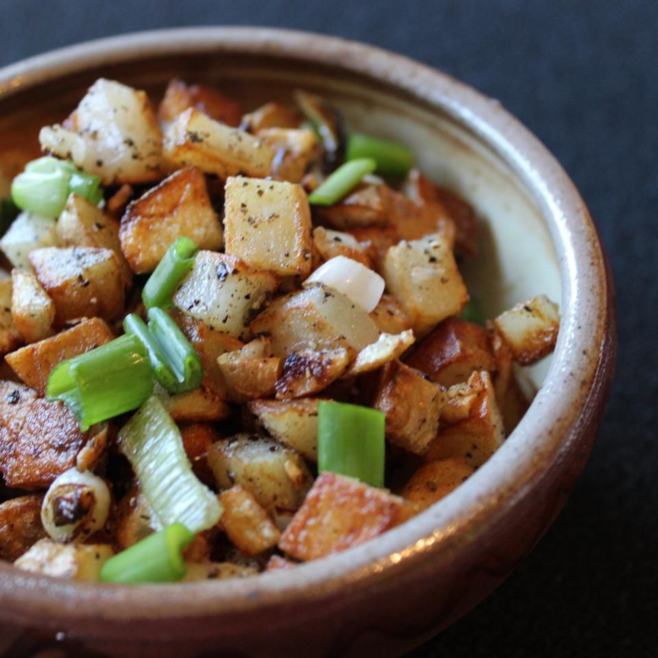 cubed potatoes, onion, and scallions in ceramic bowl