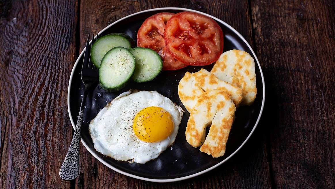 fried halloumi with an over-easy egg tomato and cucumber