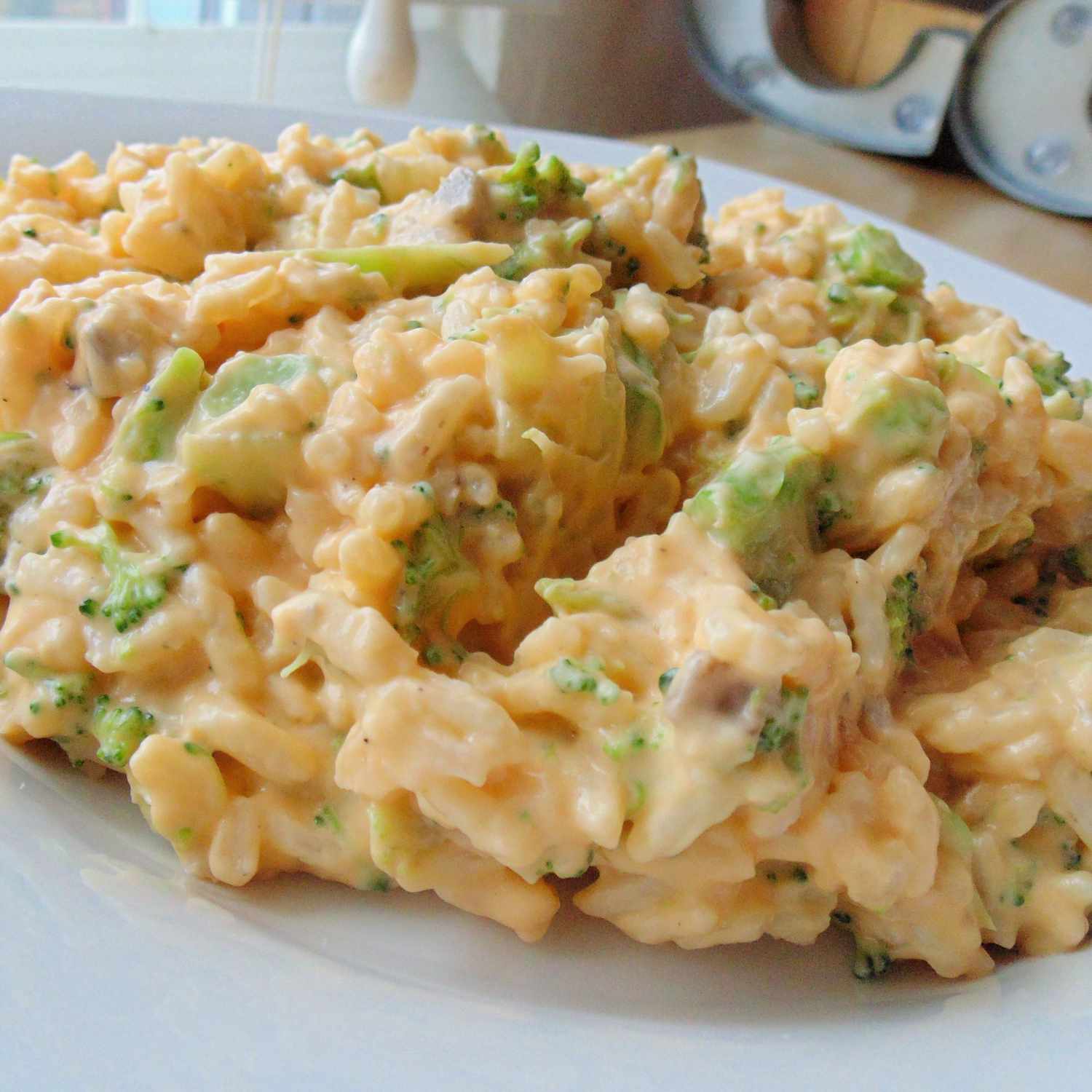 a serving of creamy-looking cheese and broccoli rice casserole on a white plate