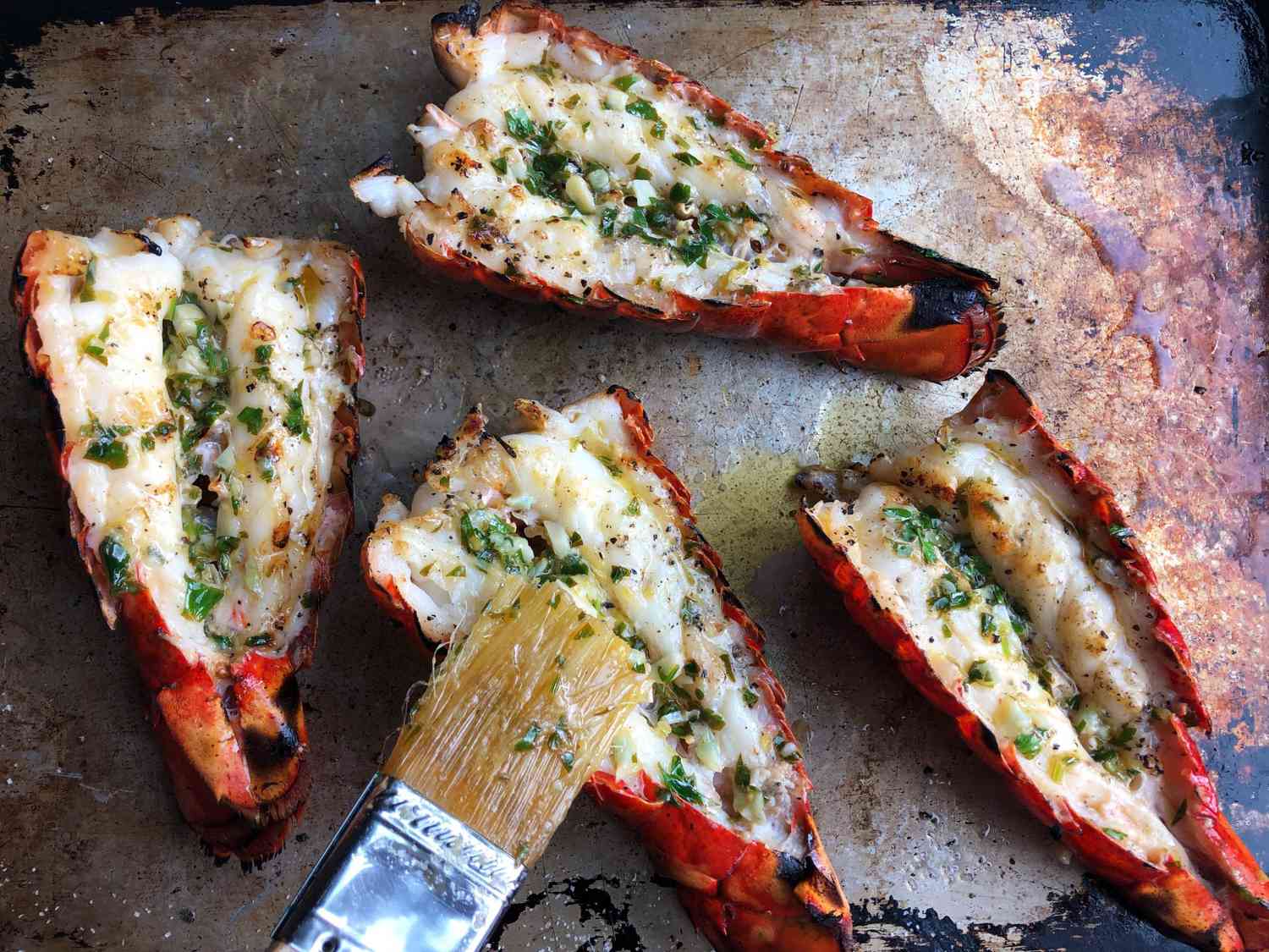 garnishing grilled lobster tails with garlic butter