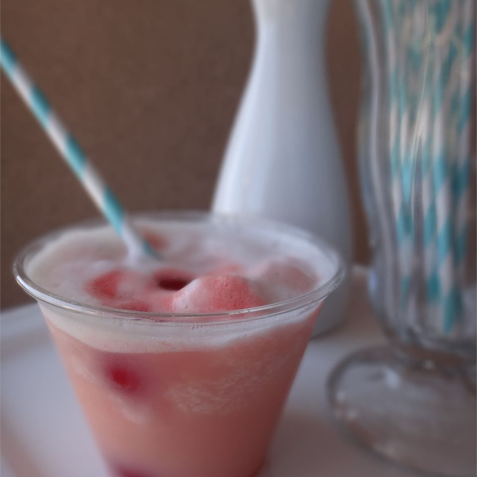 portrait shot raspberry slushy in plastic cup with striped straw