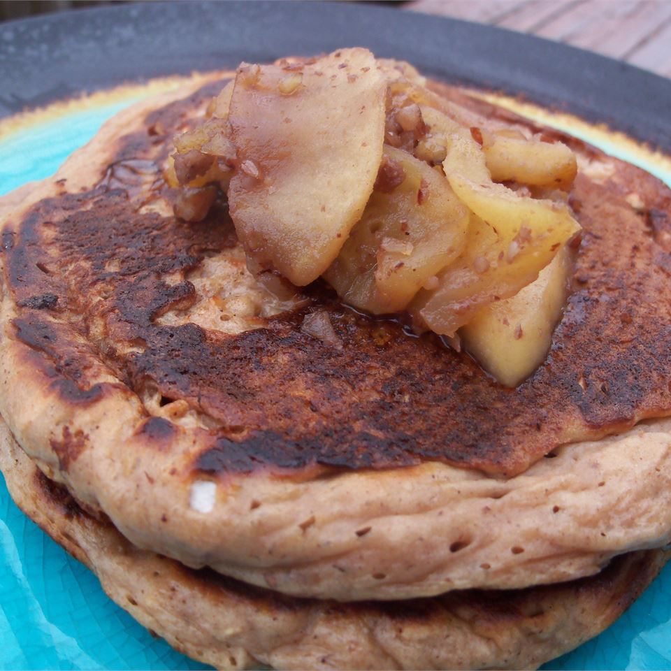 two pancakes stacked with apple topping on blue plate