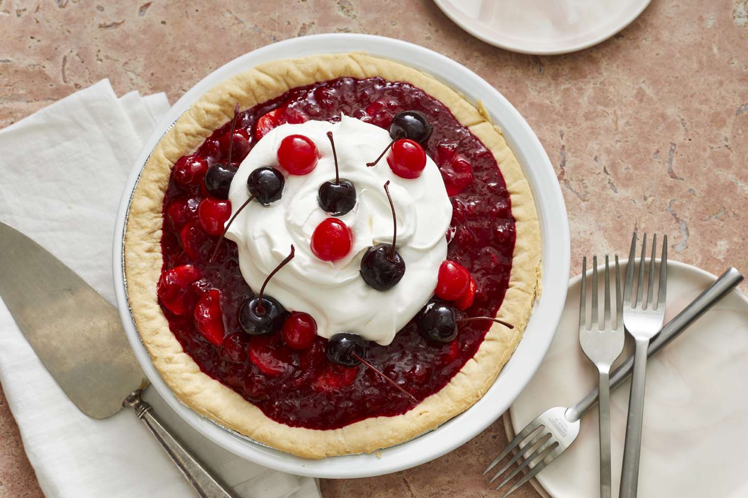 overhead angle of out of this world pie, topped with whipped cream and fresh cherries