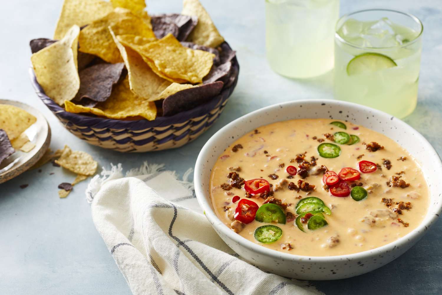 Chorizo queso dip topped with fresh chilies and served with a basket of chips and a few margaritas
