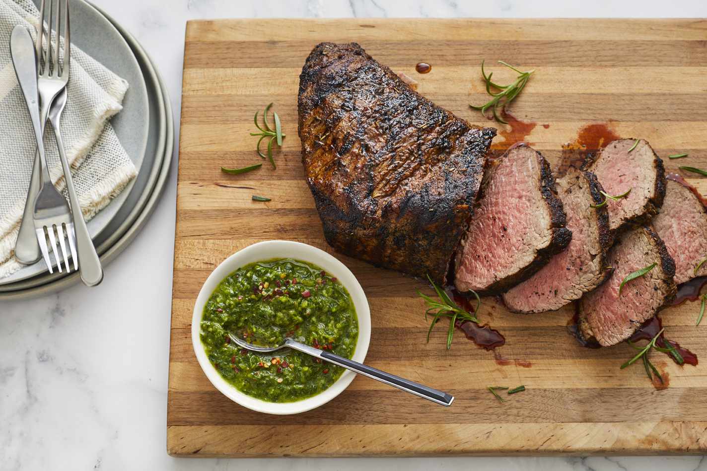 Sliced grilled Santa Maria tri-tip with fresh rosemary and bright chimichurri