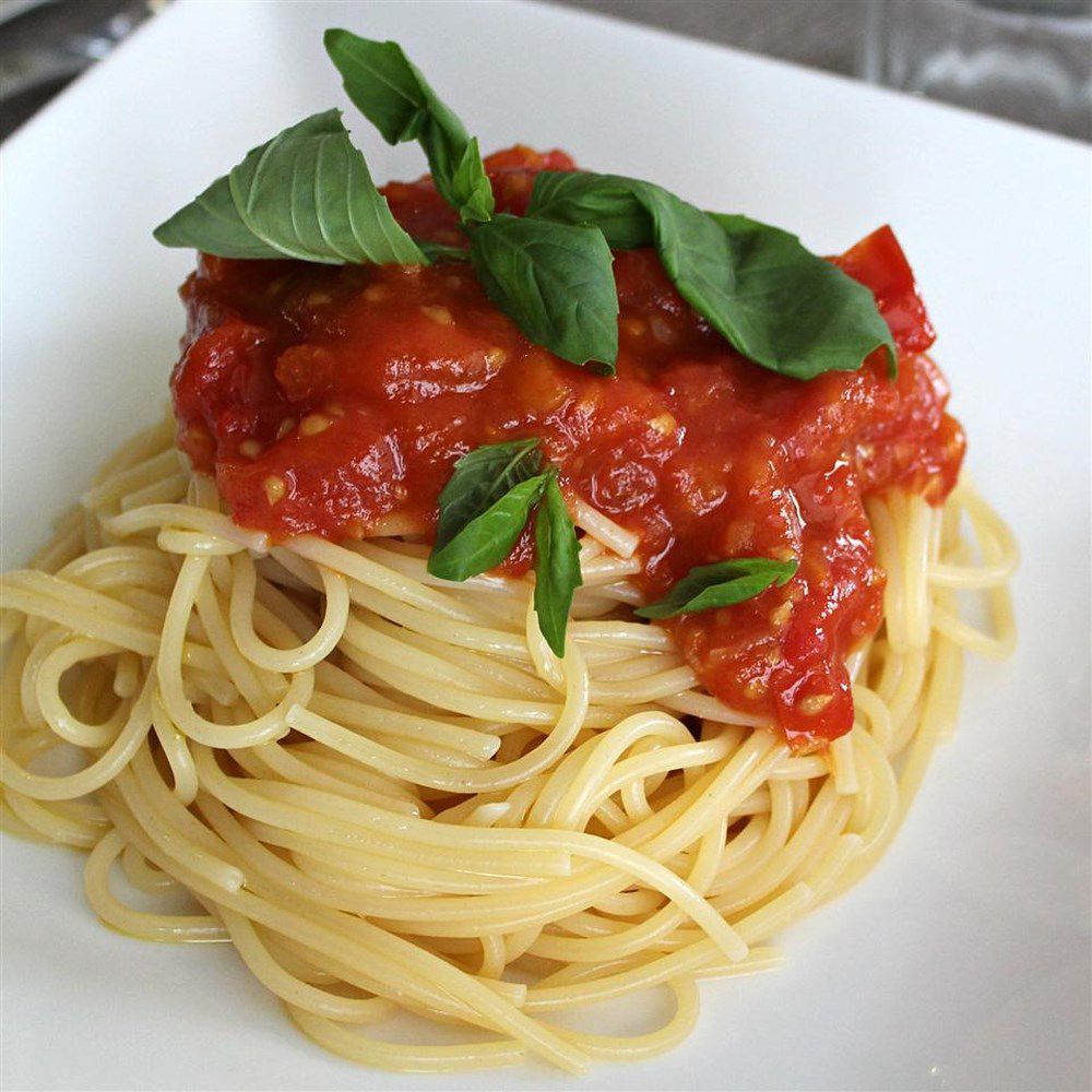plate of spaghetti with tomato sauce and fresh basil