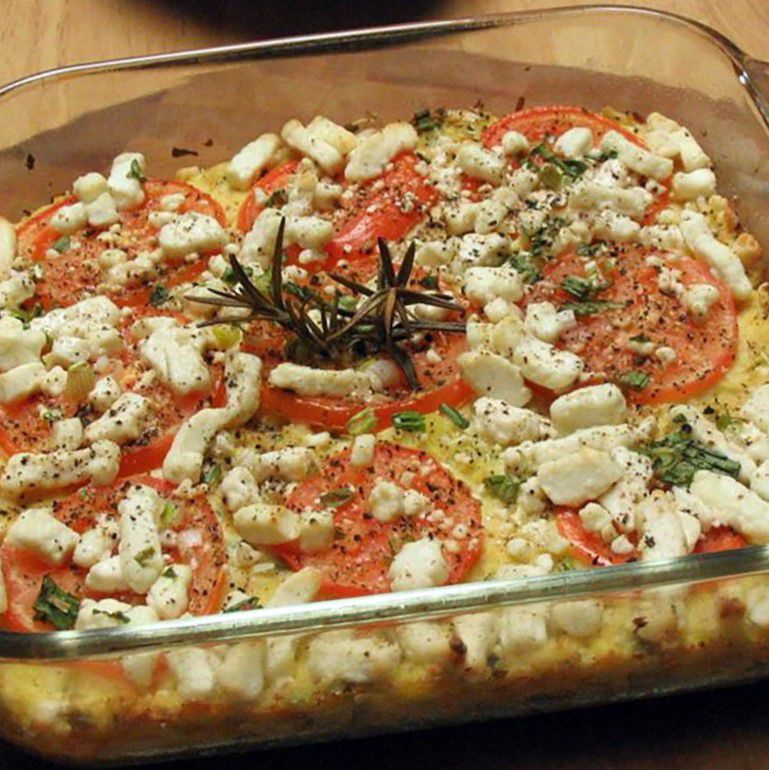 a glass baking dish with baked squash tomatoes and feta