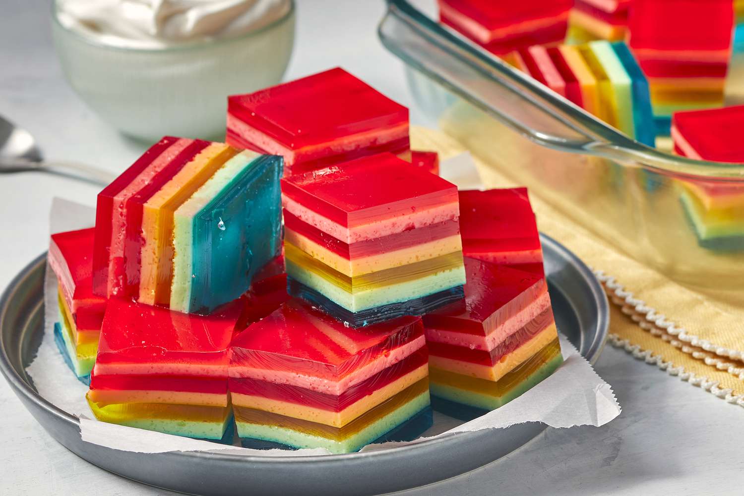 a colorful stack of seven layer gelatin salad squares.