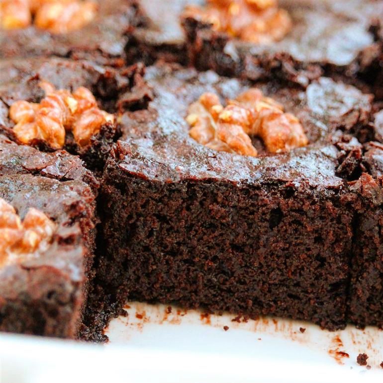 close up of vegan brownies topped with walnut halves
