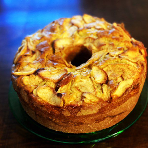 jewish apple cake baked in a tube pan with apples on top