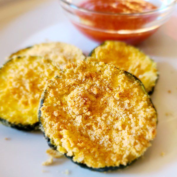 air fryer zucchini chips with breading and a side of ketchup