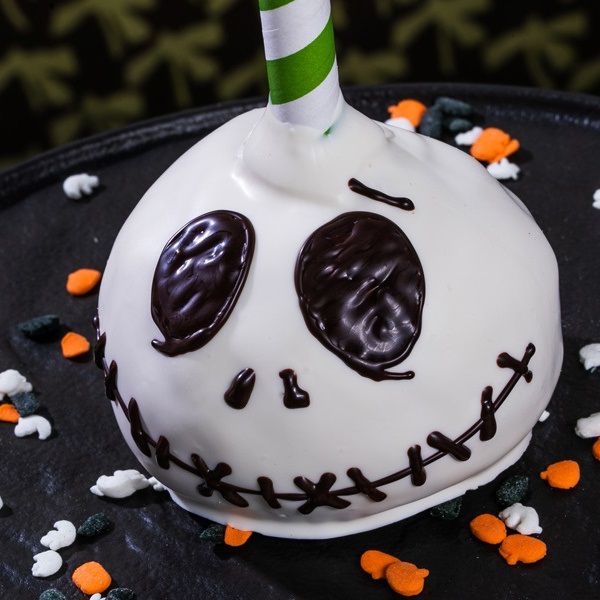 pumpkin pie pop decorated as Jack Skellington's head using white icing with black details to recreate a Disney Halloween treat