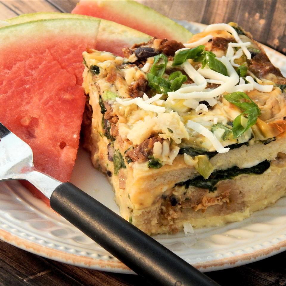 brunch casserole made with french bread and topped with cheese beside a slice of watermelon