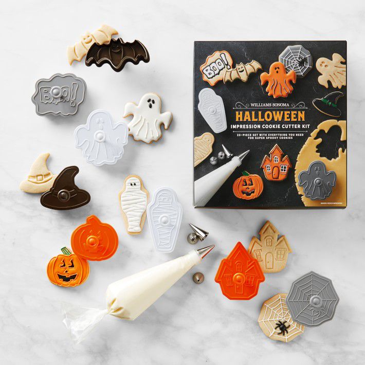 halloween cookie cutter kit on marble countertop with cookies and piping bags