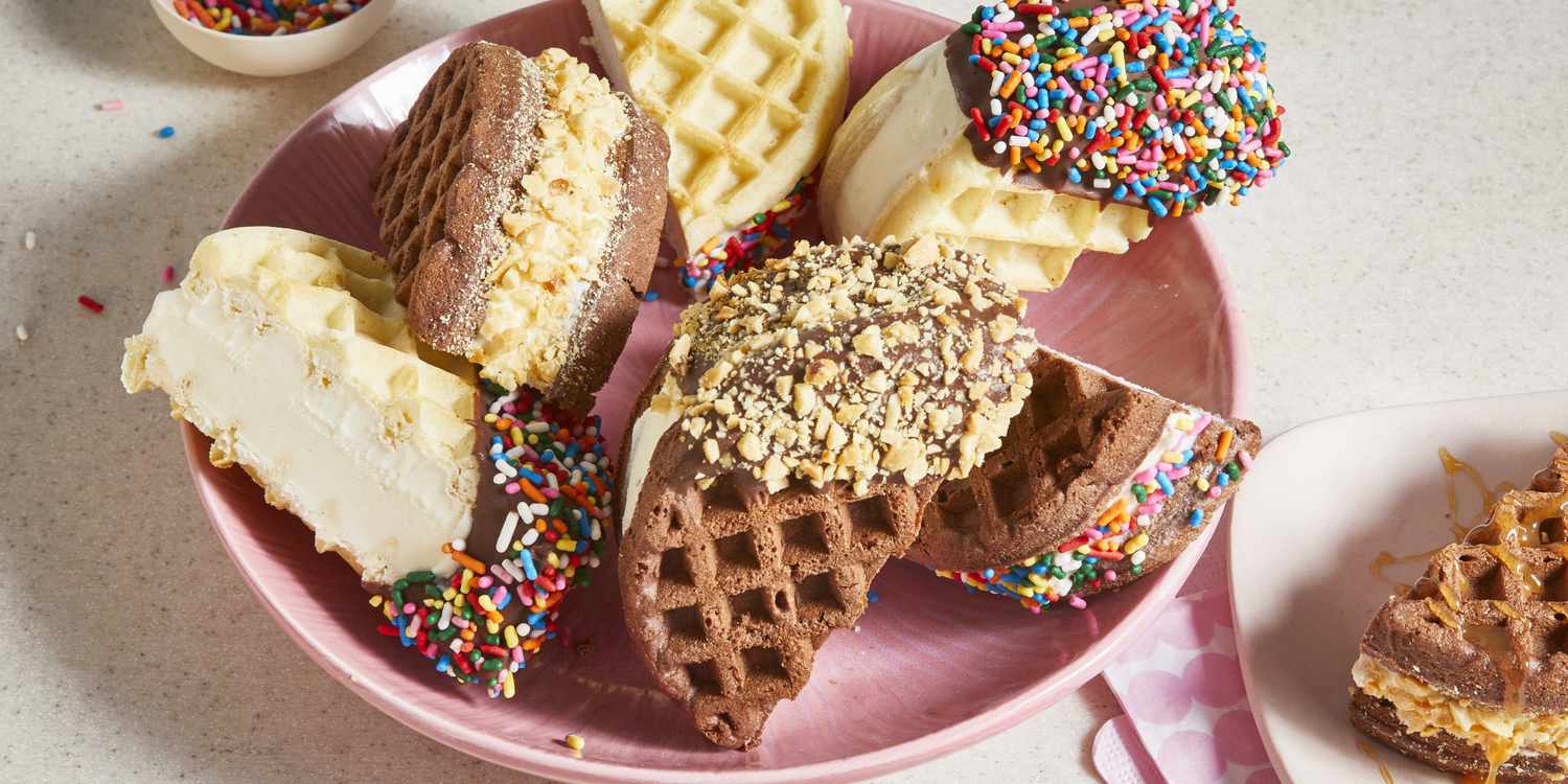A pink plate full of ice cream waffle sandwiches, dipped in chocolate and a variety of toppings