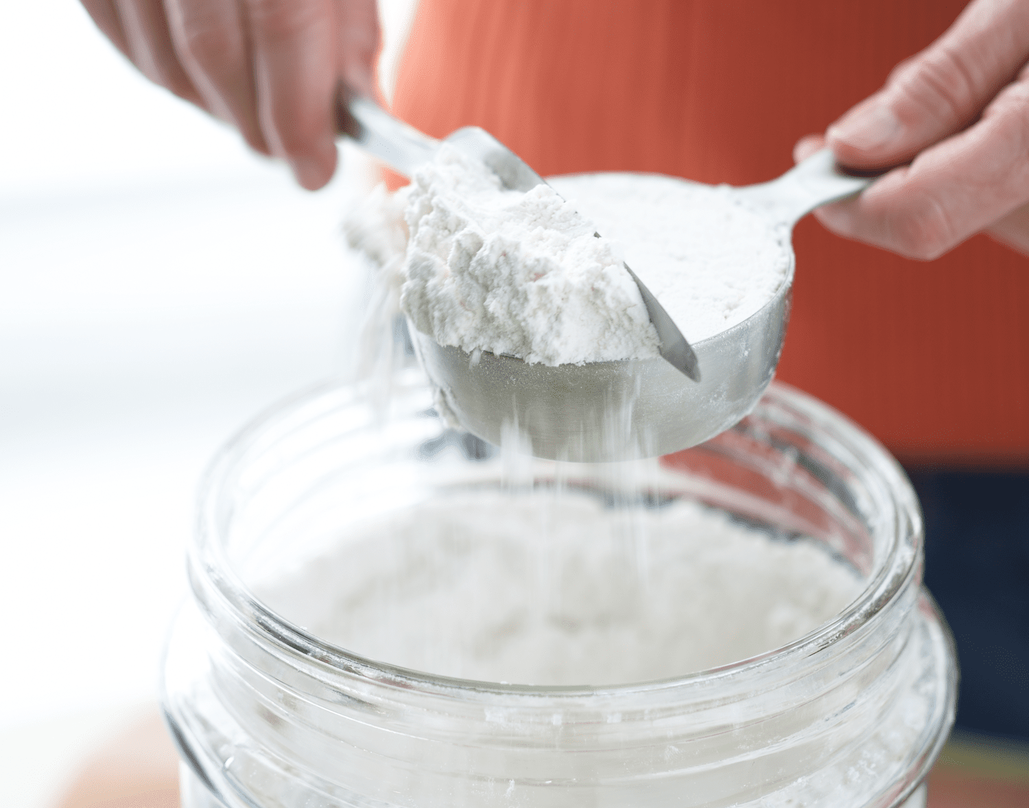 scraping excess flour off measuring cup