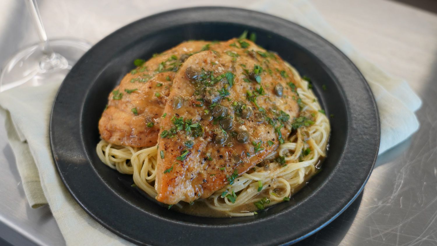 chicken breasts on pasta in a black bowl