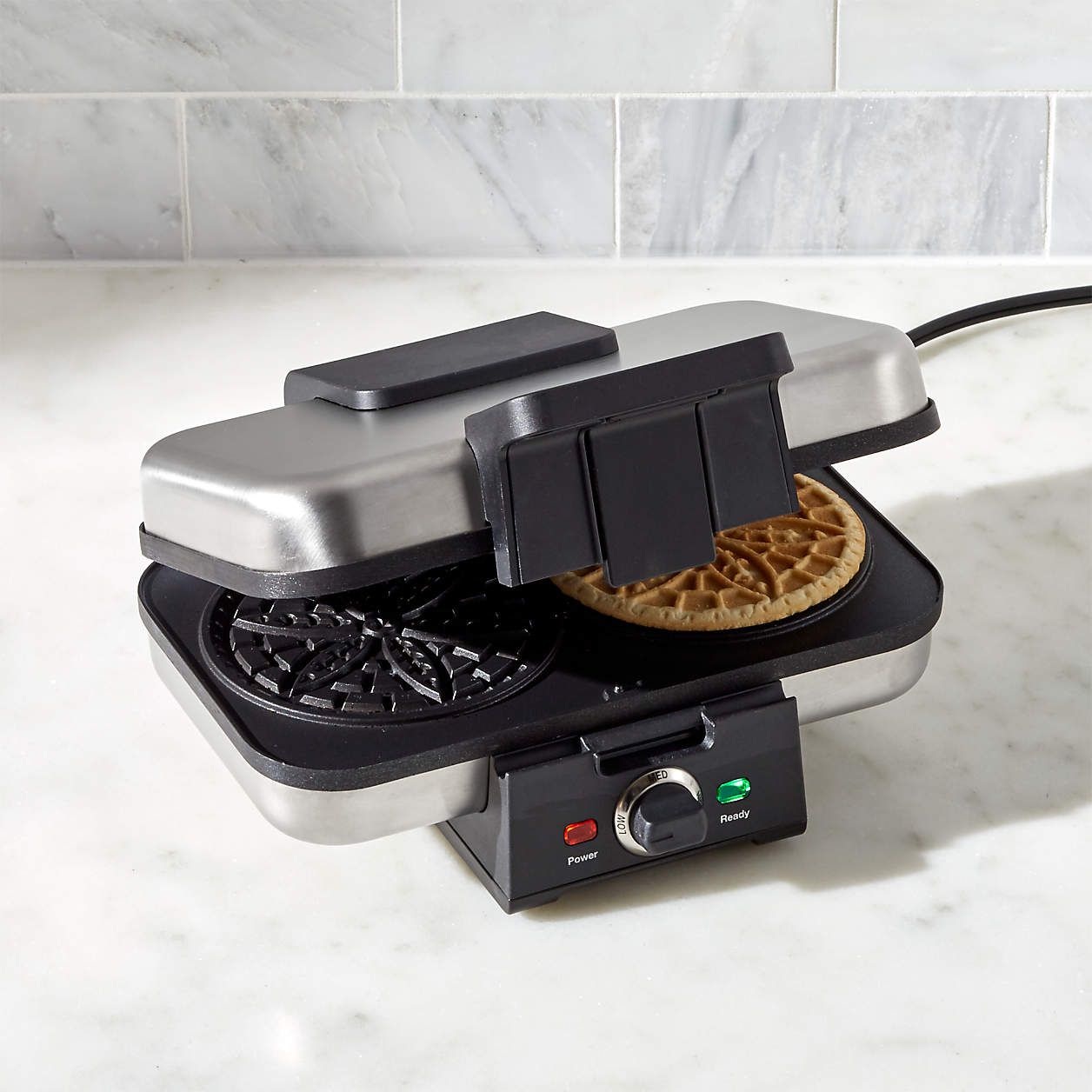 pizzelle maker with one pizzelle on countertop