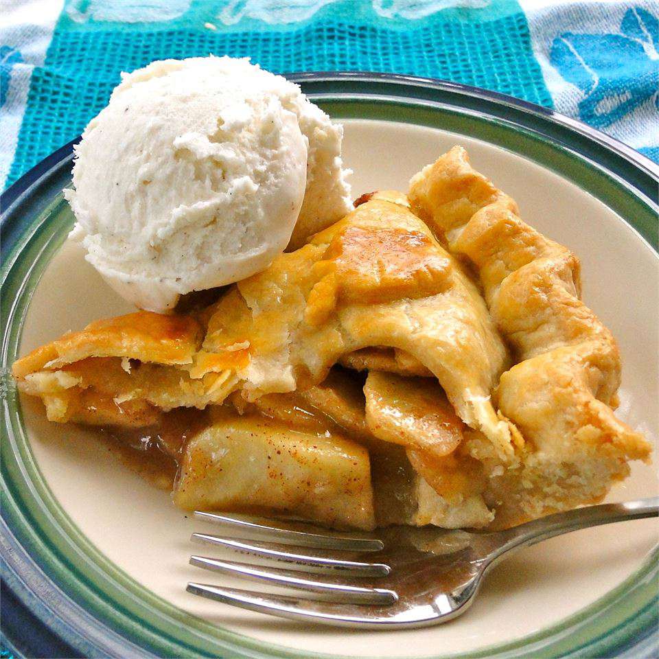 slice of homemade Old-Fashioned Apple Pie served with a scoop of vanilla ice cream