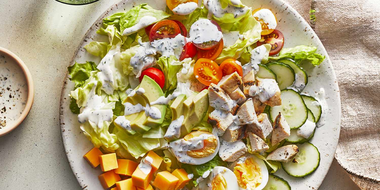 An overhead view of a chef's salad with grilled chicken and black pepper ranch dressing
