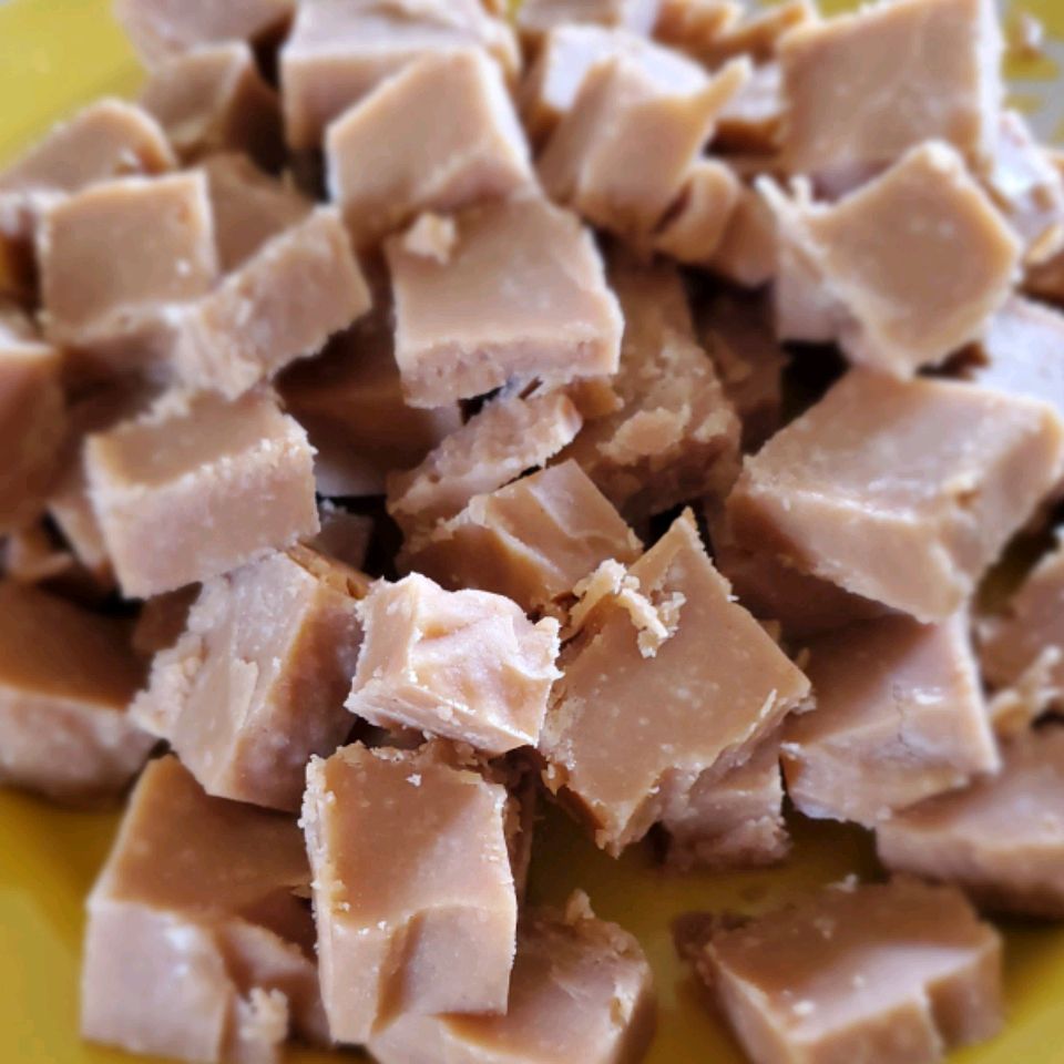 closeup of squares of pale brown fudge piled in a bowl