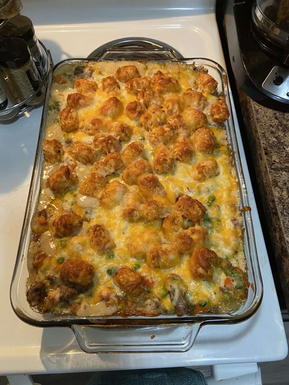 top-down view of a glass baking dish of cheese-topped Tater Tot casserole