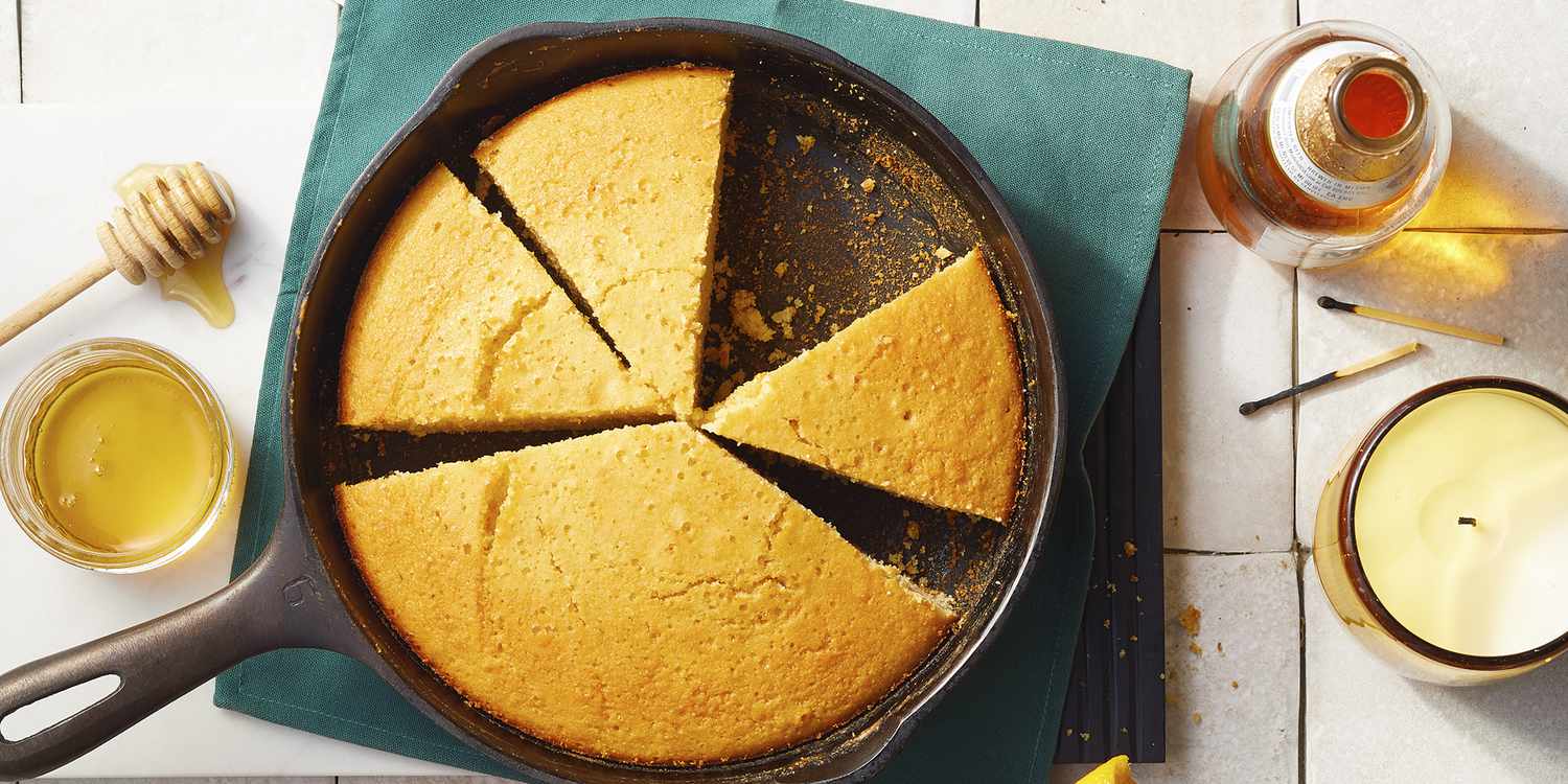 overhead view of grandmother's buttermilk cornbread partially sliced in a round cast iron skillet