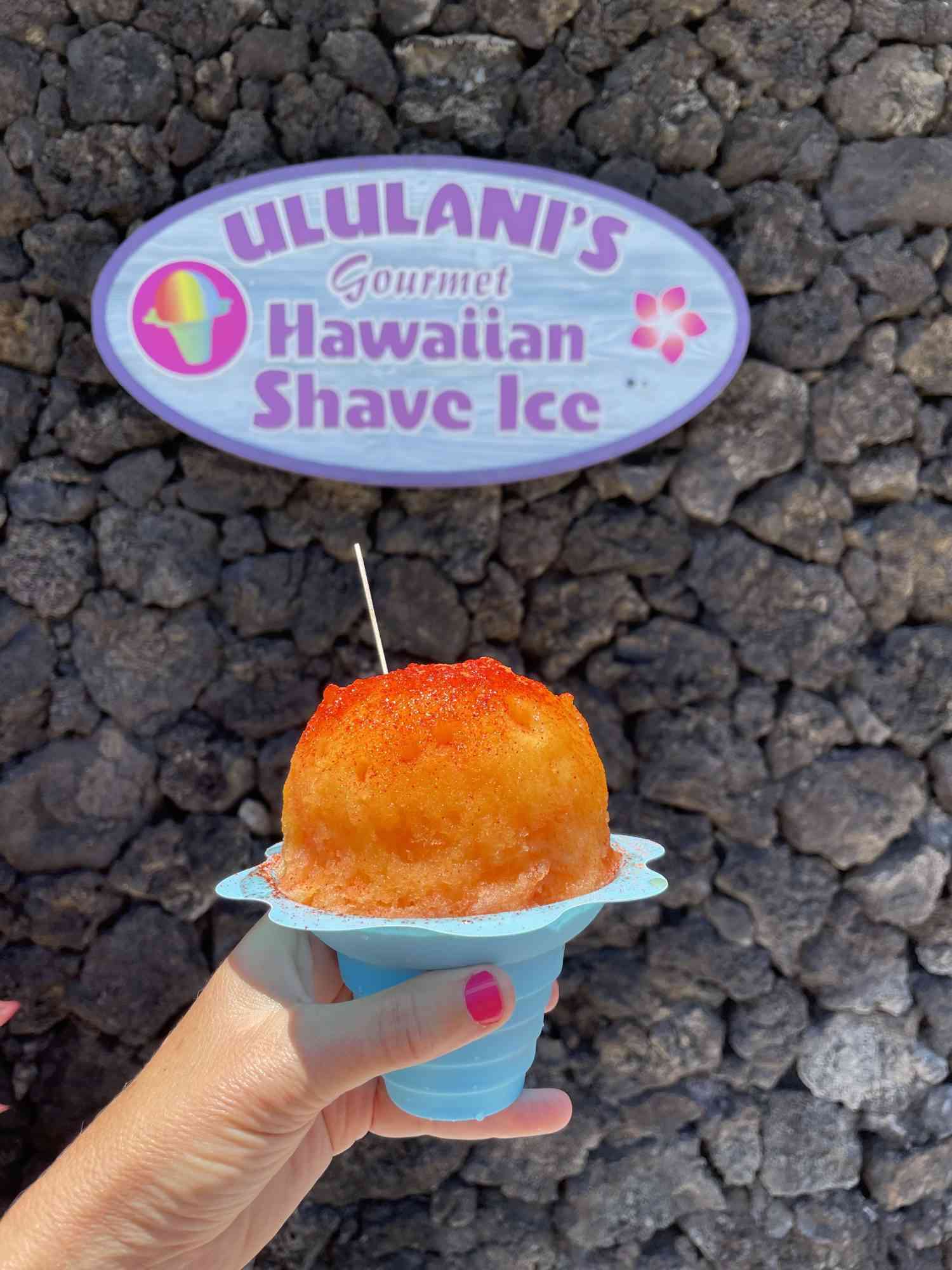 Ululani's shave ice single with sign in background