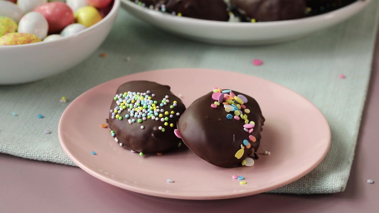 chocolate covered, candy coated easter eggs on a round pink palte