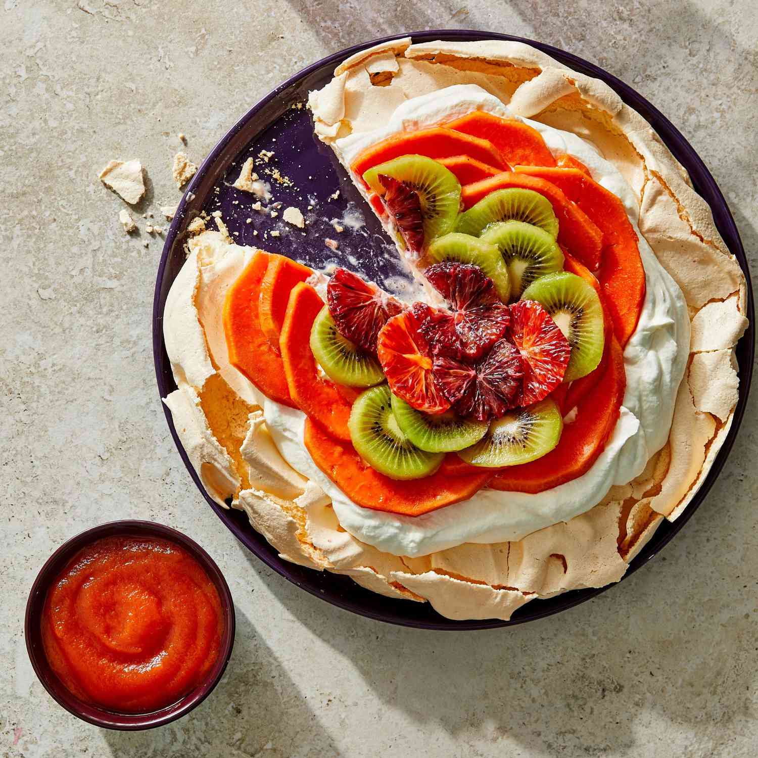 Papaya, blood orange, and kiwi on a layer of cream sitting atop a meringue base