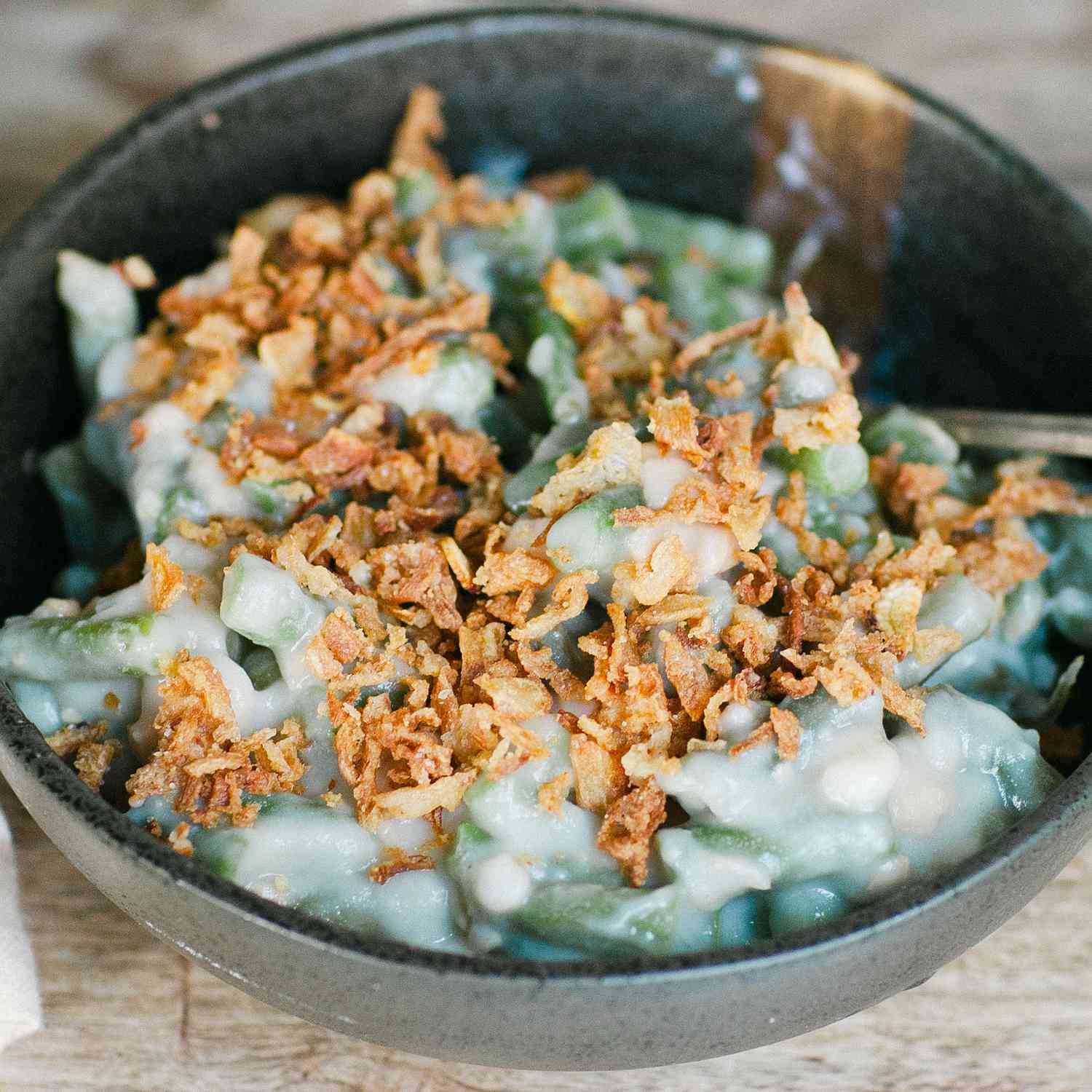 a close up view of slow cooker green beans topped with crispy onions.