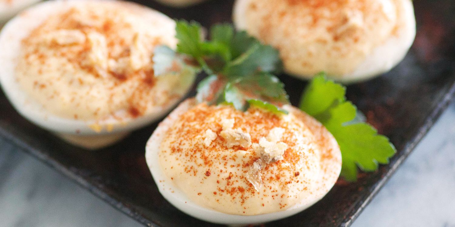 a close up view of deviled eggs on a dark platter