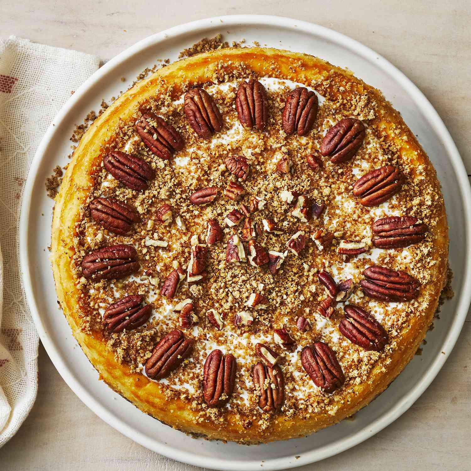 an overhead view of a whole pecan cheesecake loaded with chopped and halved pecans.