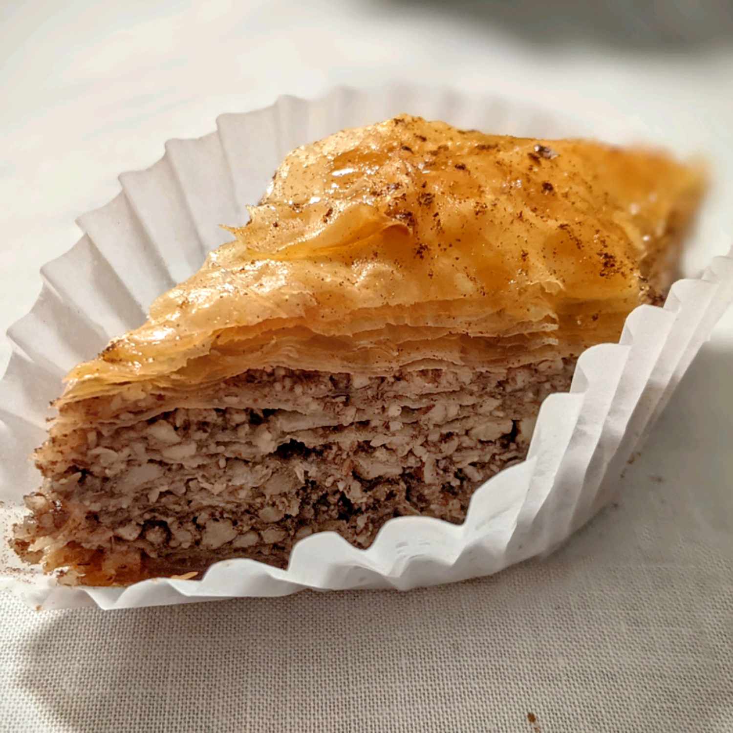 a close up view of a single piece of baklava and it's super flaky layers