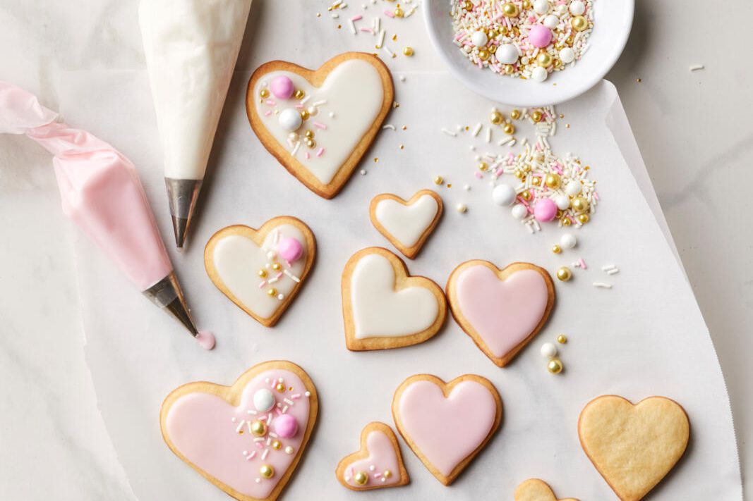 overhead view of heart shaped cookies decorated with red, pink, and white royal icing for valentine's day