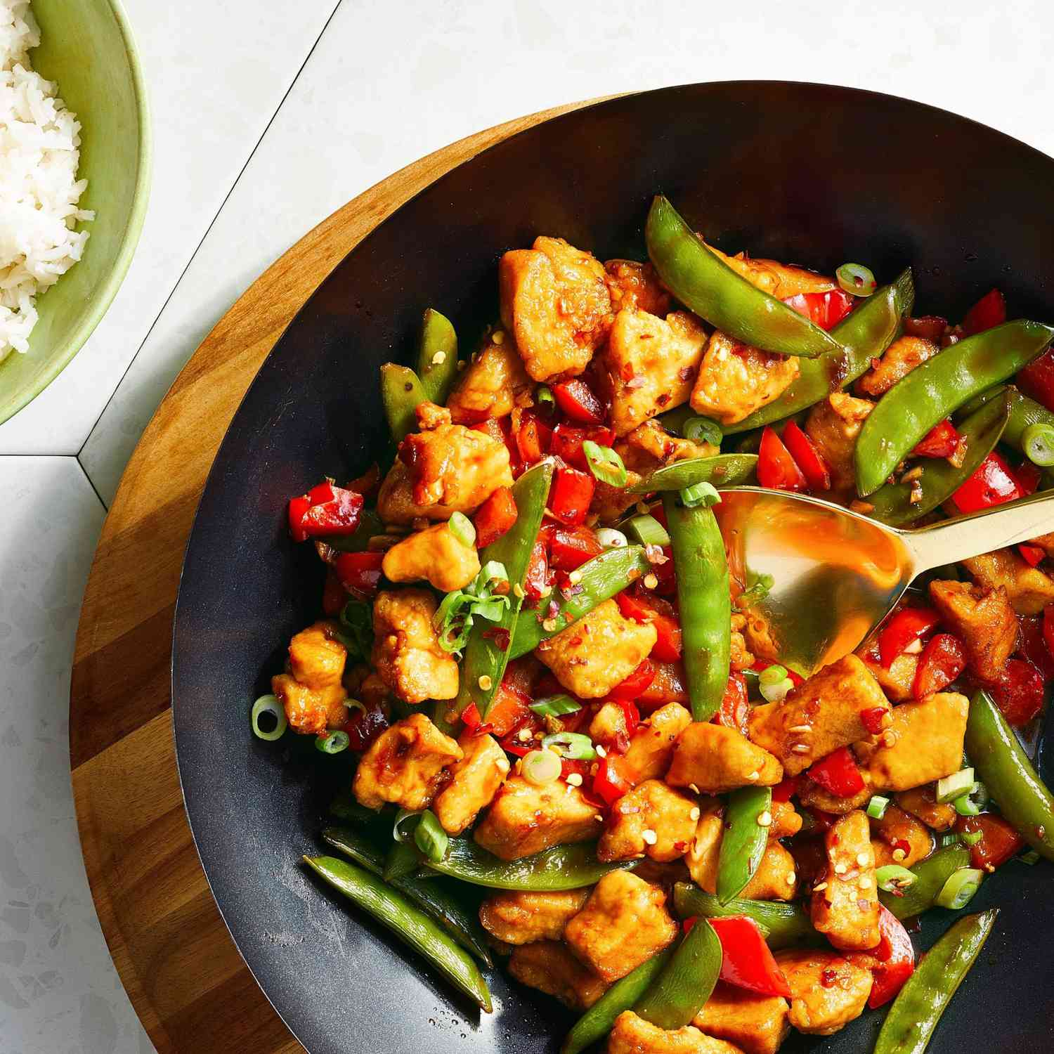 Chicken, peppers, and snap peas stir-fried in a wok