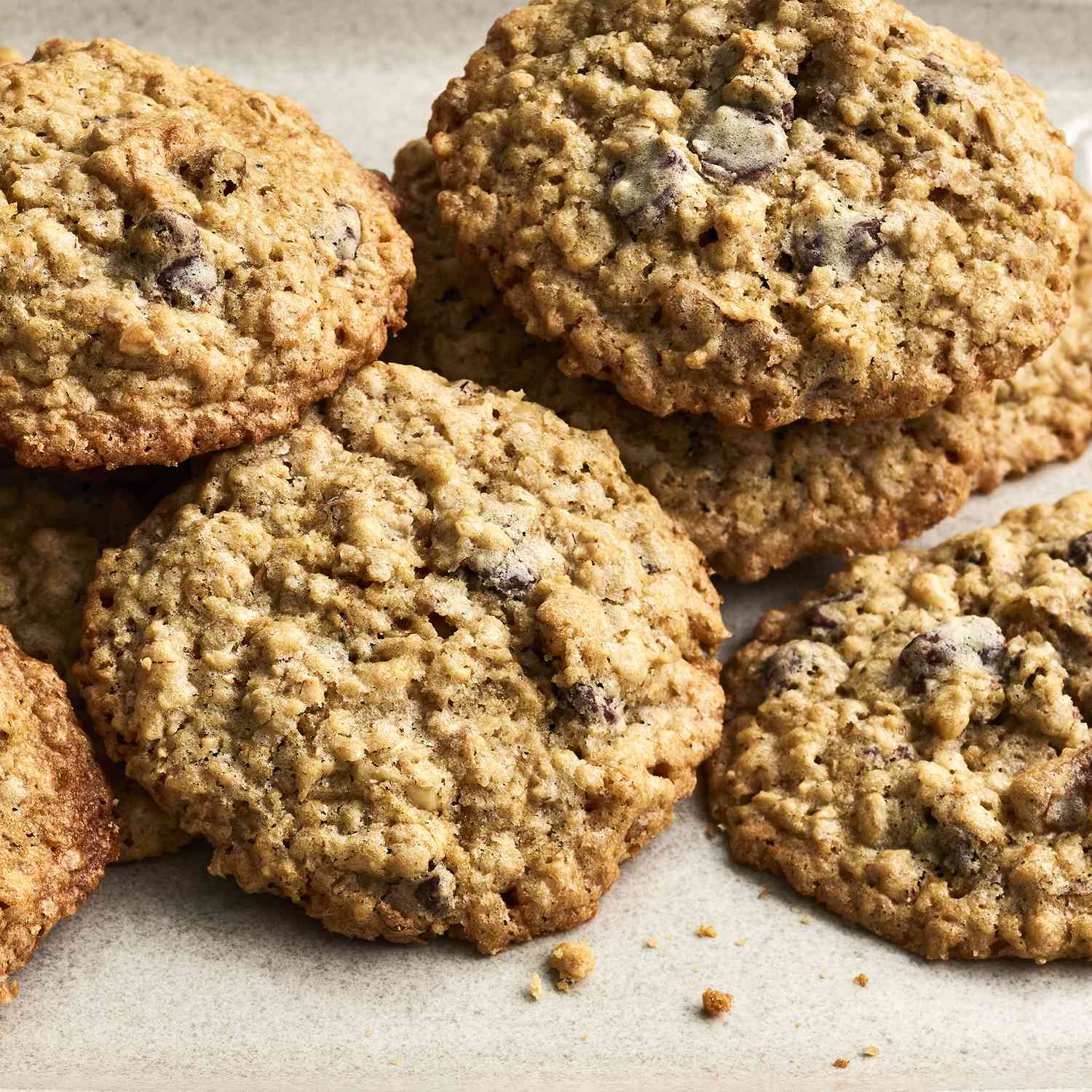 a close up view of a pile of chewy chocolate chip oatmeal cookies