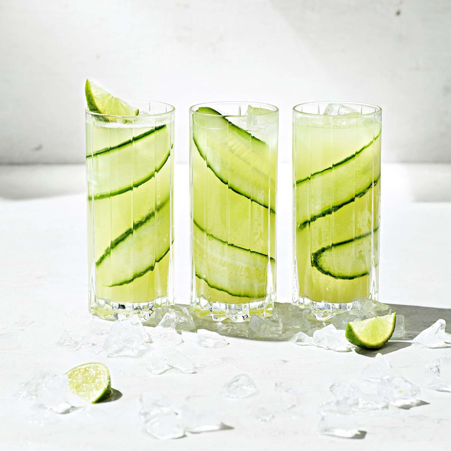 Three lime beverages with cucumber slices
