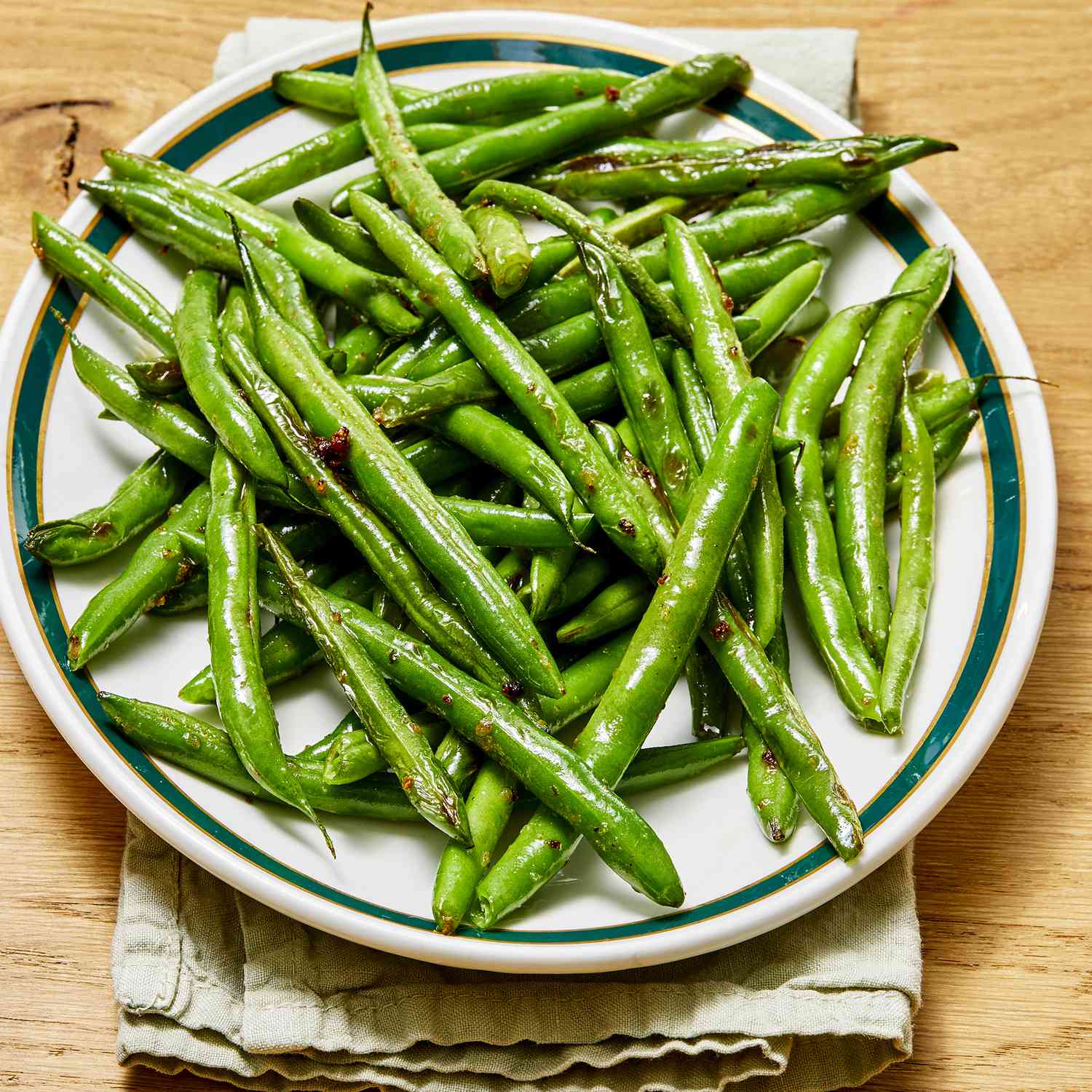 a low angle, close up view of pile of sauteed garden fresh green beans on a platter.