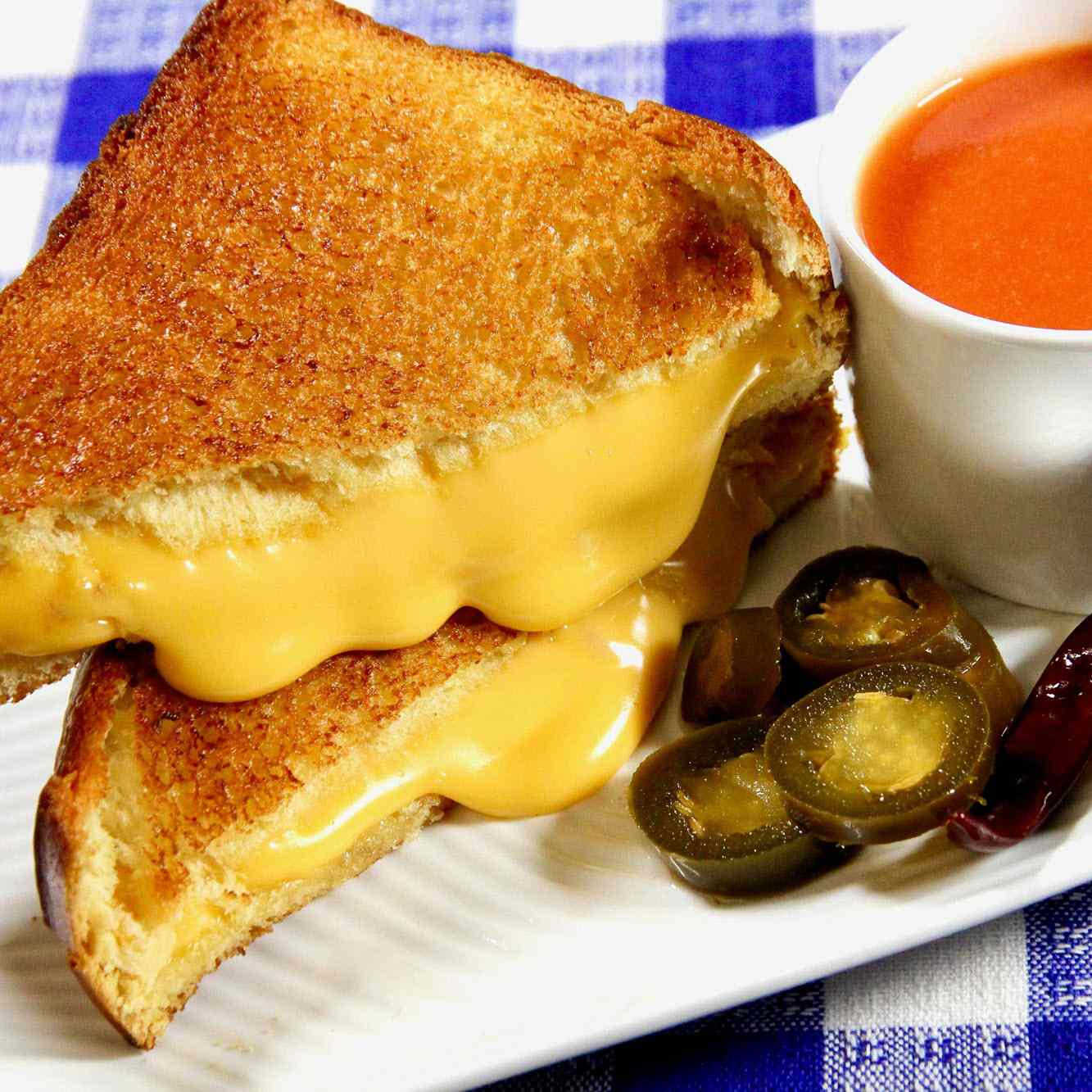 Grilled cheese sandwich on a plate with tomato soup