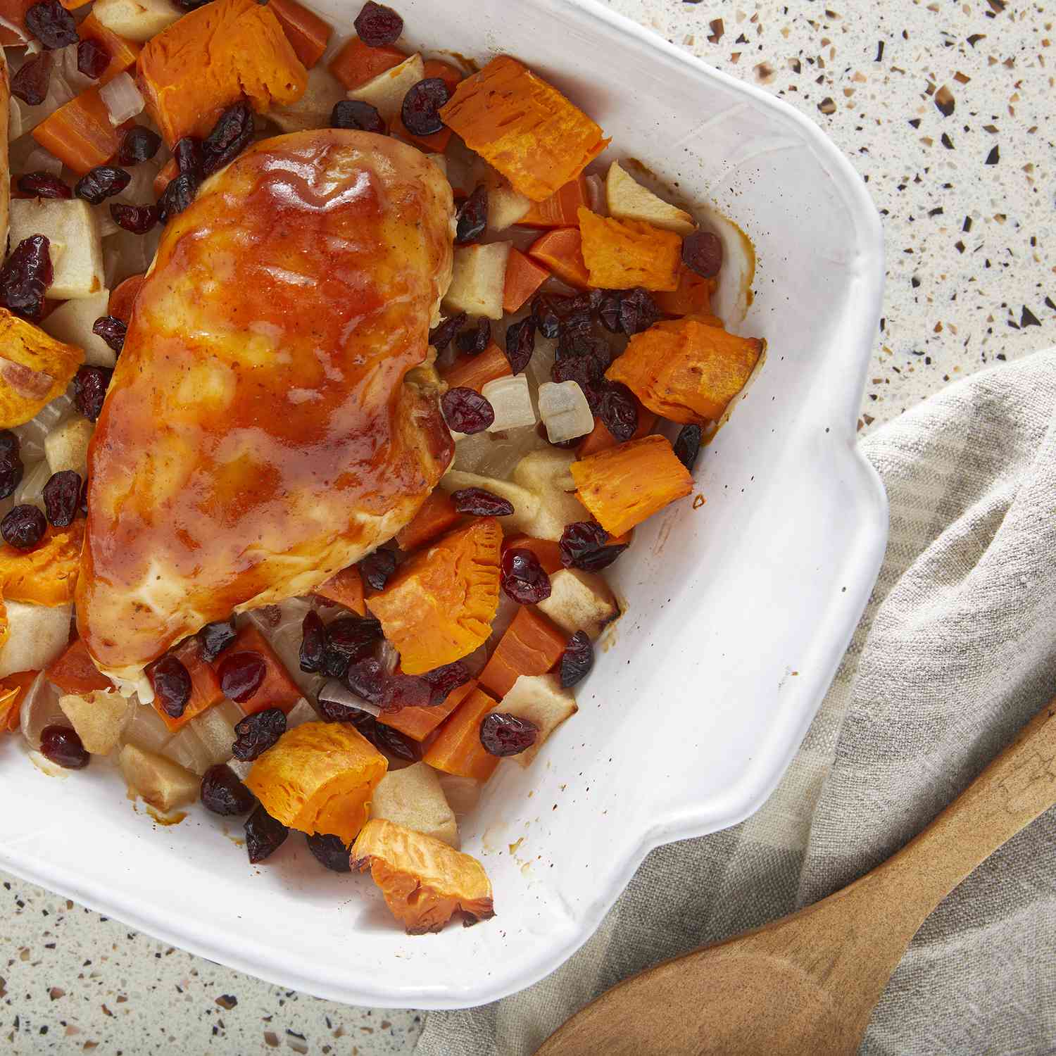 overhead view of barbecue chicken bake with sweet potatoes and cranberries served in a casserole dish