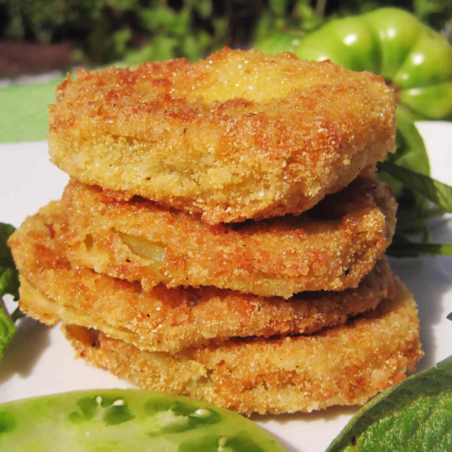 a low angle view looking into a stack of golden-brown fried green tomatoes