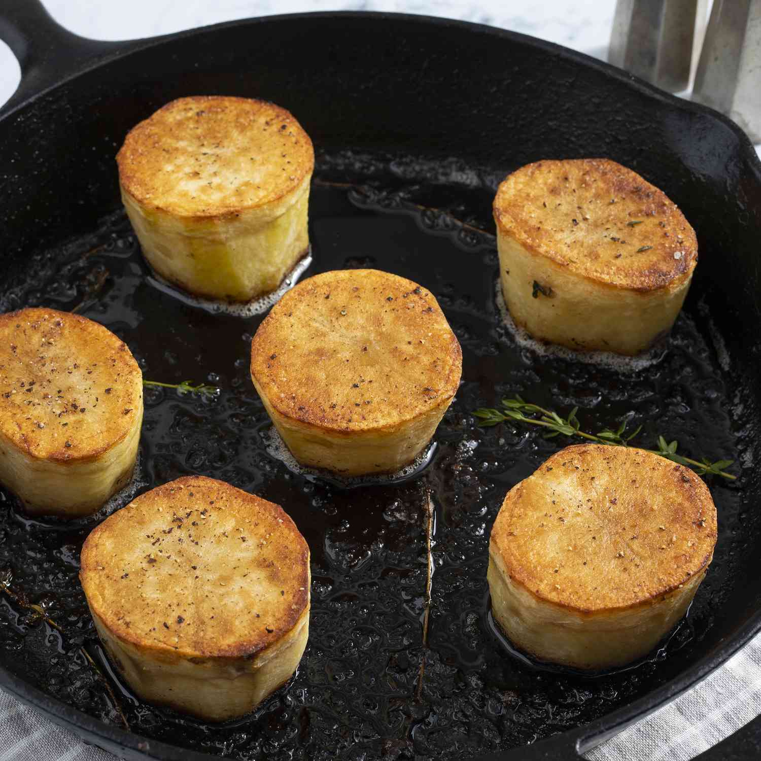 overhead view of fondant potatoes in a skillet