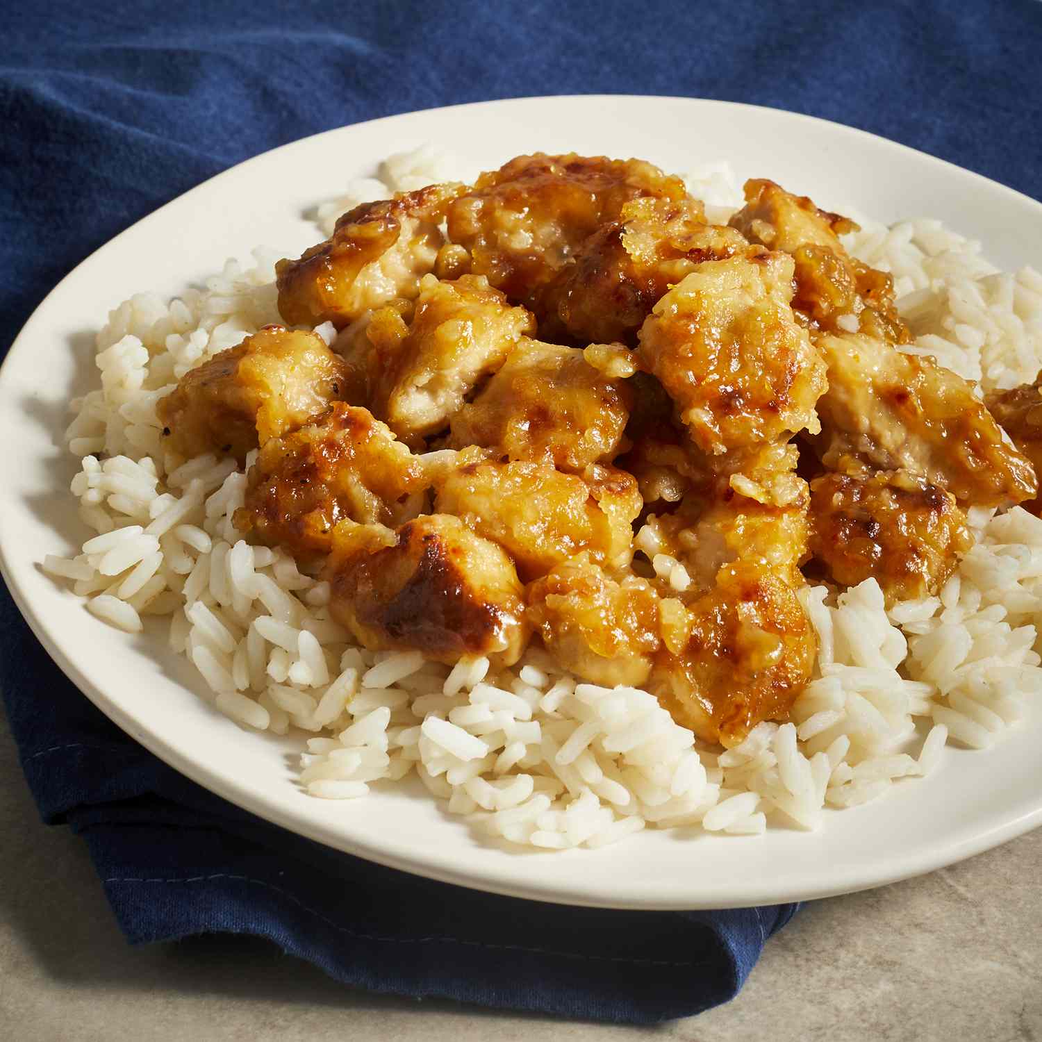 close up view of asian orange chicken in a bowl with white rice