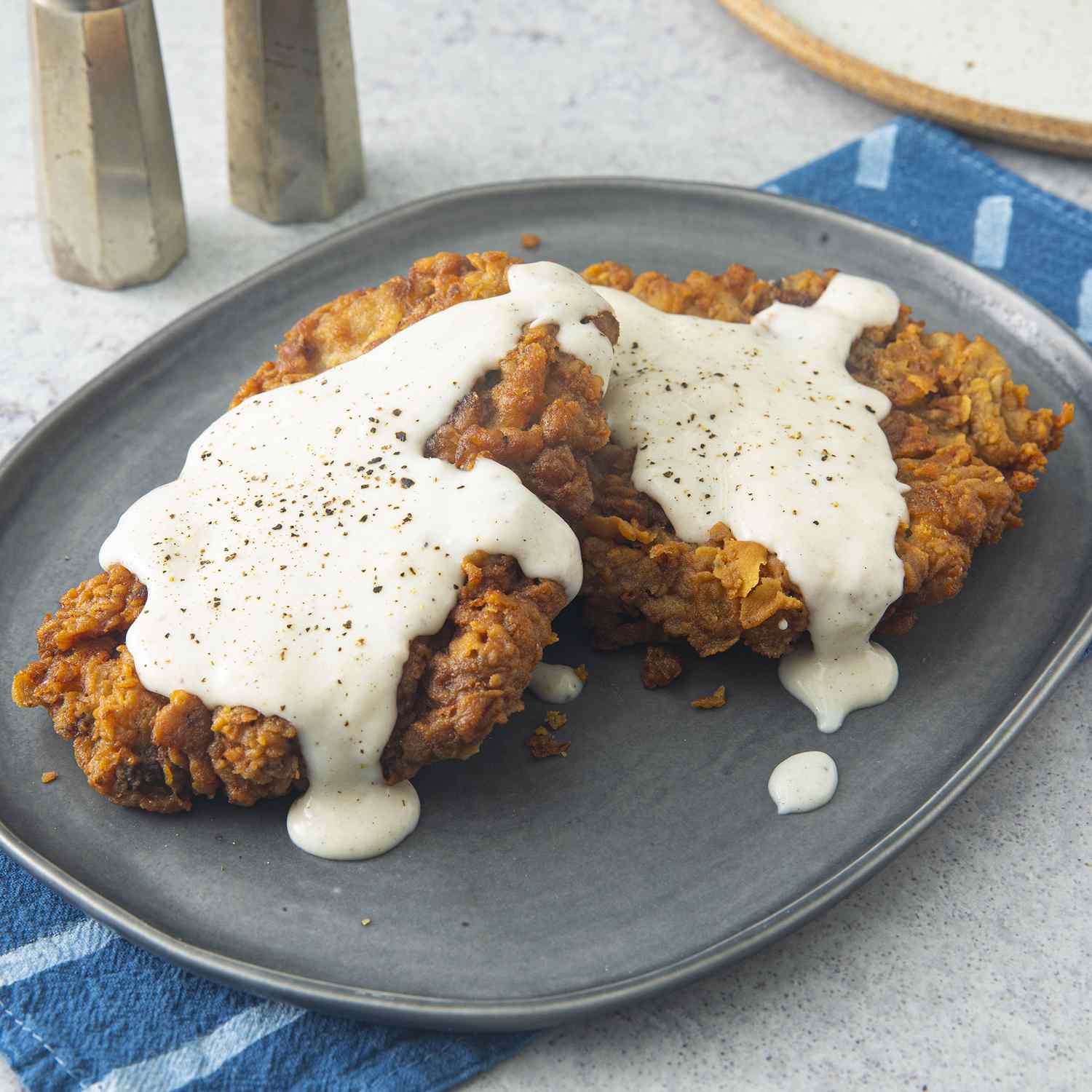 close up view of Chicken Fried Steak with gravy on top, on a plate