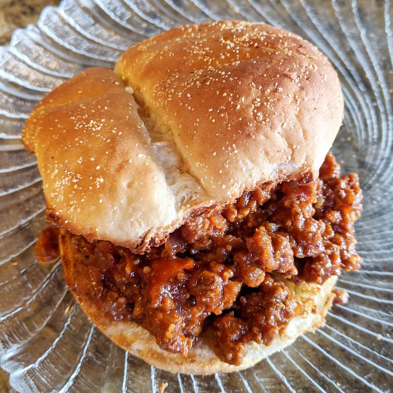 close up view of a sloppy joe in a bun, on a plate