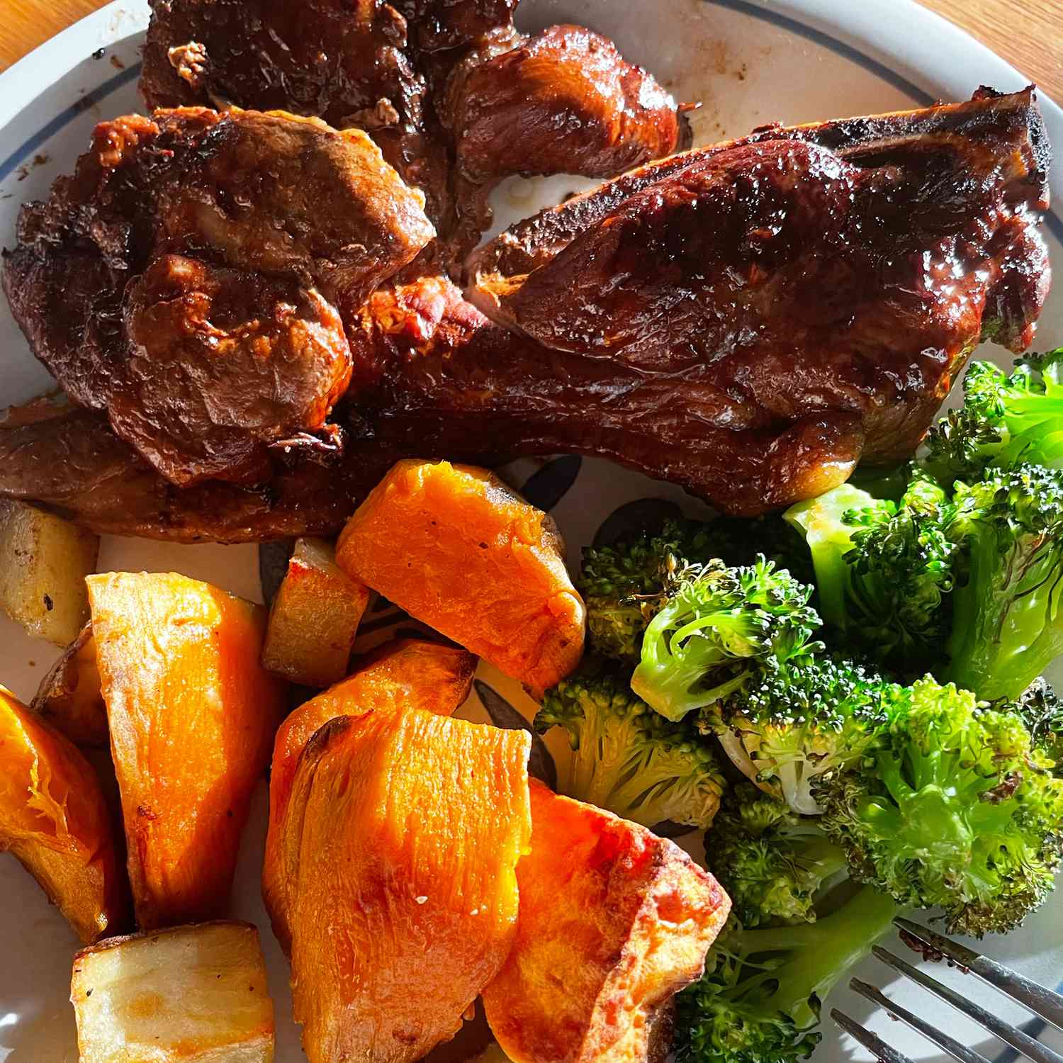 close up view of pork steaks with broccoli and sweet potatoes