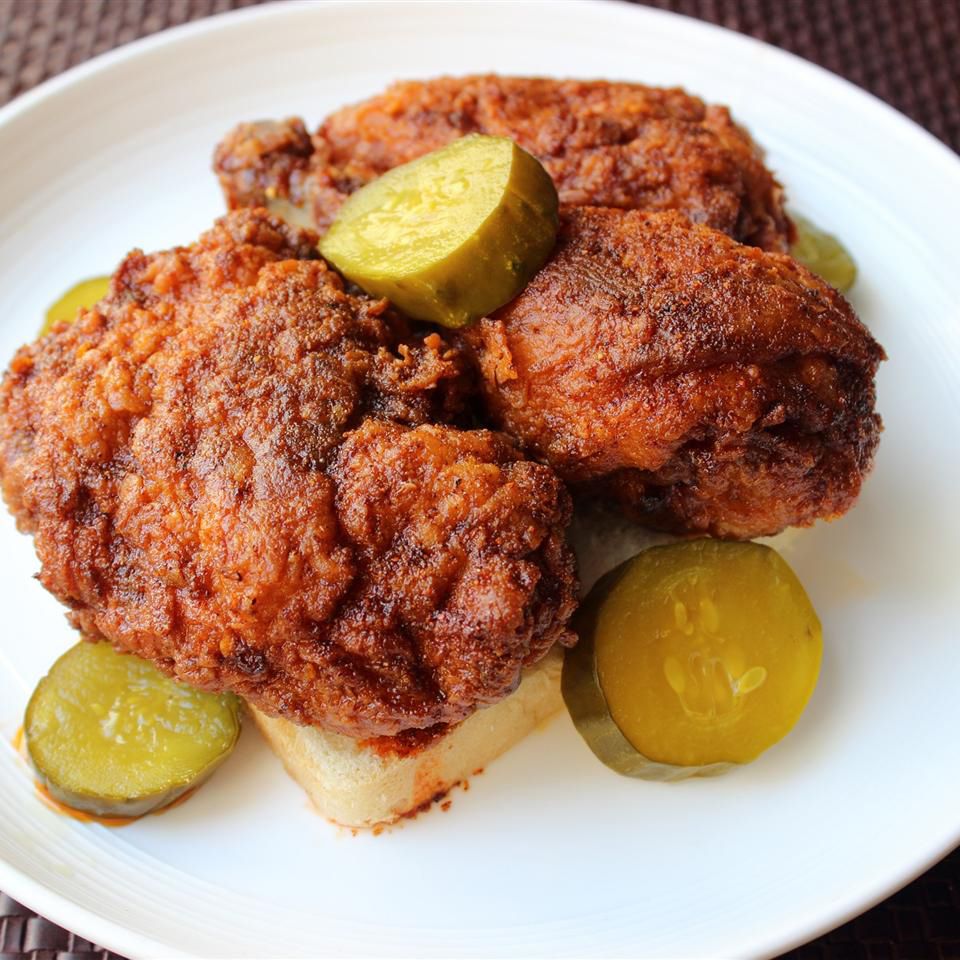close up view of Chef John's Nashville Hot Chicken on a slice of bread, with pickle slices