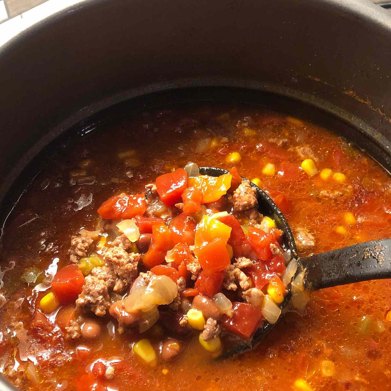 close up view of Slow Cooker Taco Soup in a pot, with a ladle